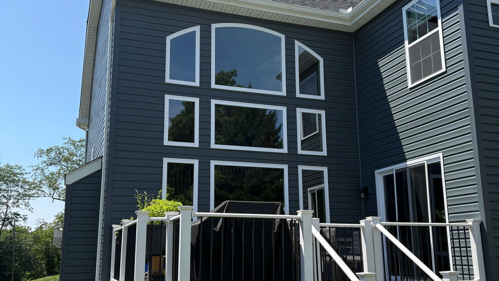 Modern dark navy home with rooftop solar panels and a covered back deck in FirstEnergy Ohio territory