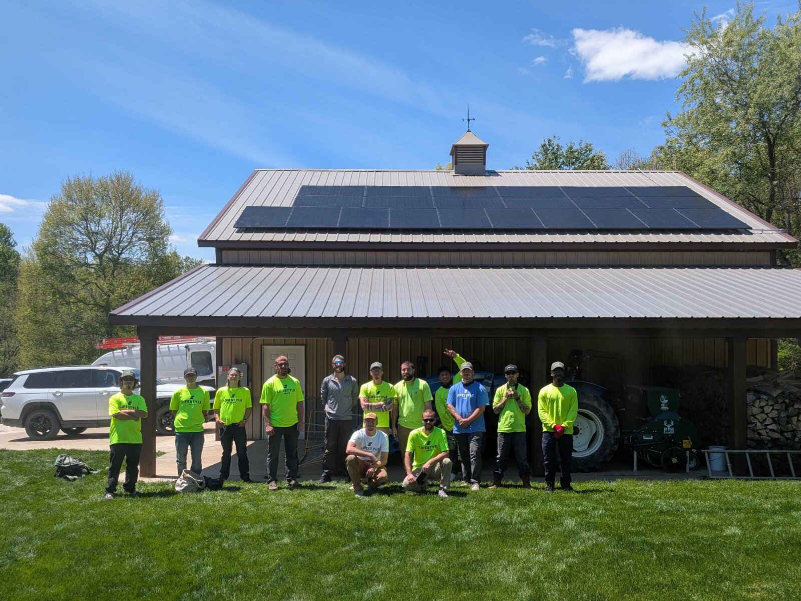 Lifestyle Solar installation crew gathered in front of a building with rooftop solar panels