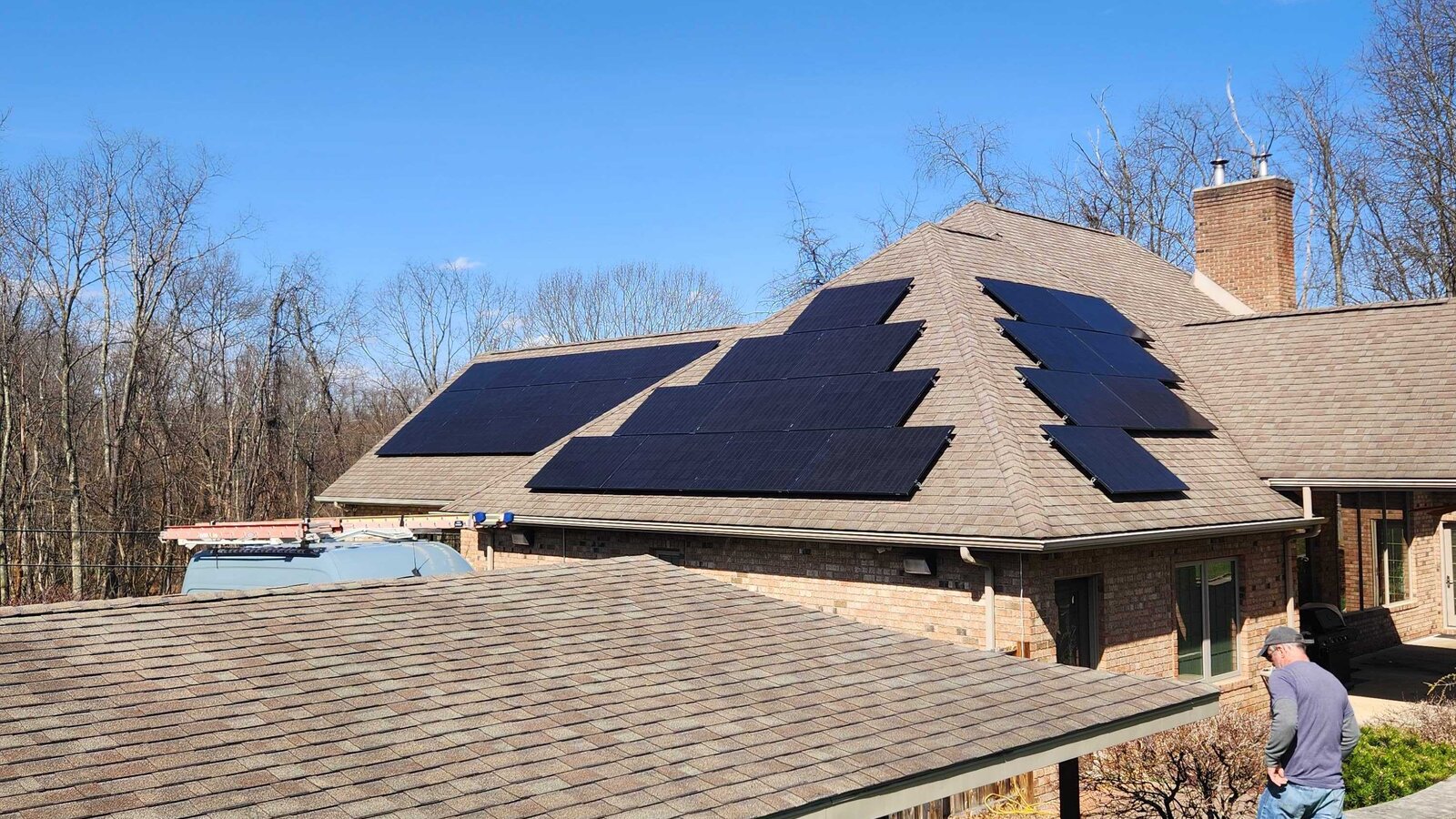 Single-story brick home with rooftop solar panels under a clear blue sky in Penelec territory